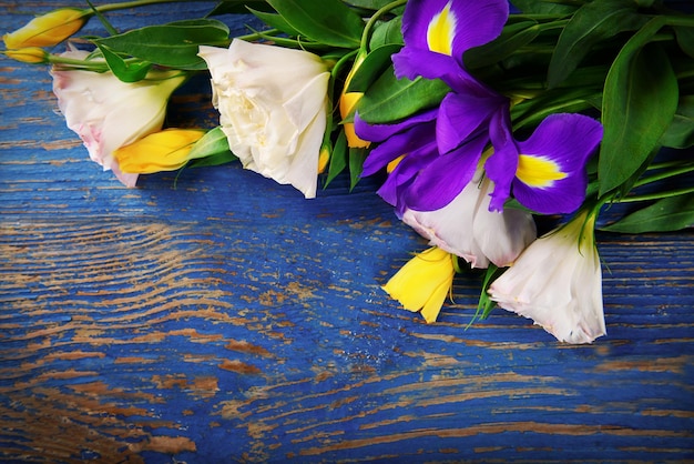 Hermoso ramo de flores en el espacio de copia de fondo de madera azul