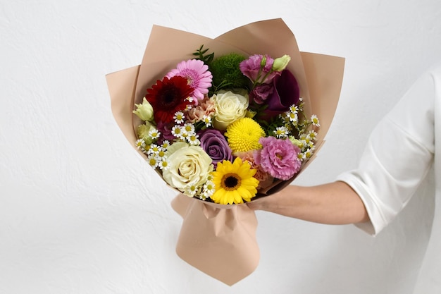Hermoso ramo de flores en manos de una foto de mujer para postal y catálogo de una tienda de flores en línea entrega de flores frescas