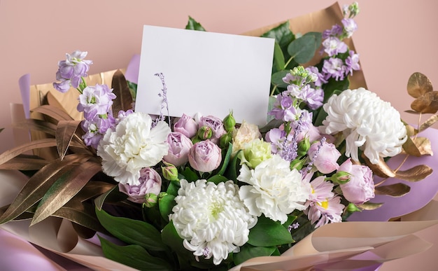 Hermoso ramo de flores mixtas con tarjeta de felicitación en blanco