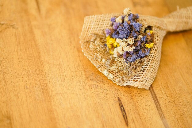 Hermoso ramo de flores secas colocado en una mesa de madera