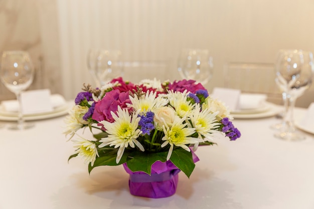 Foto hermoso ramo de flores sobre la mesa. decoración festiva del banquete. espacio para texto.