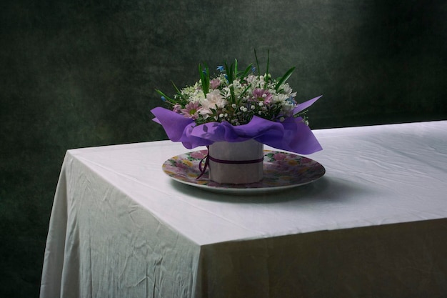 Un hermoso ramo de flores sobre la mesa con un mantel blanco