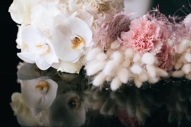 Hermoso ramo de novia blanco para la novia con orquídeas en un fondo oscuro