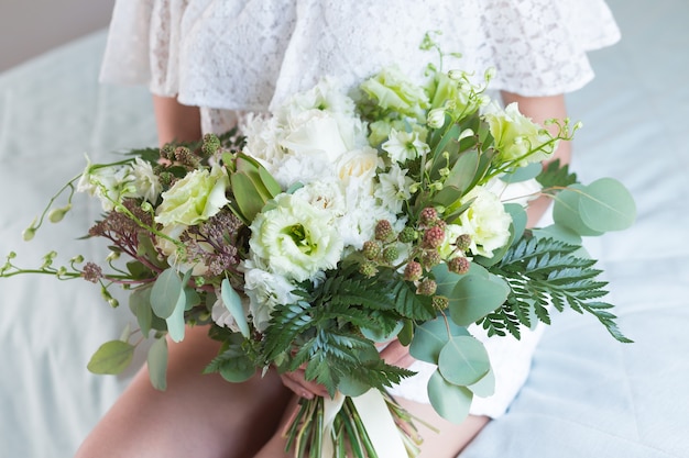 Hermoso ramo de novia con diferentes flores en manos de la novia.