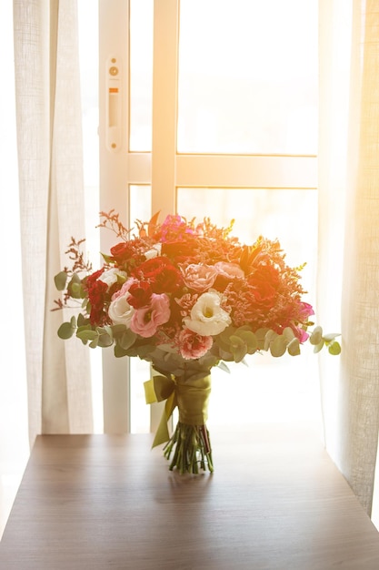 Hermoso ramo de novia con flores naturales y frescas, con colores en las hojas de marsala.