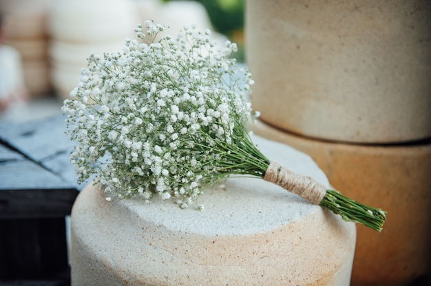 Un hermoso ramo de novia de gypsophila se encuentra en una jarra de arcilla.