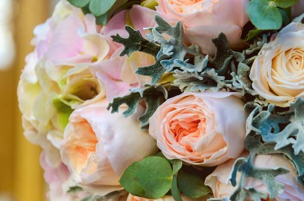 Hermoso ramo de novia solemne de una novia de rosas y eucaliptos se encuentra en los rieles de madera