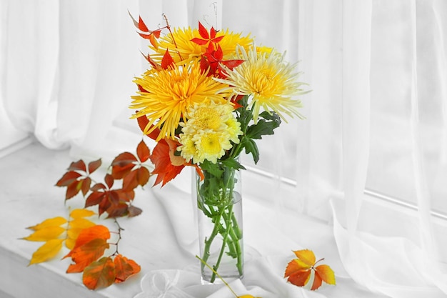 Hermoso ramo de otoño con flores de crisantemos en el alféizar de la ventana