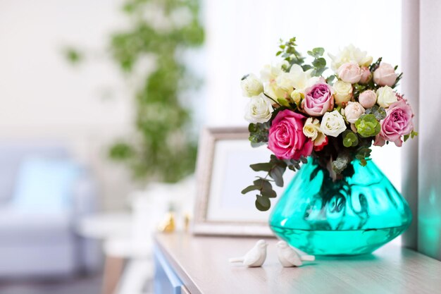 Foto hermoso ramo de rosas coloridas en jarrón de vidrio sobre la mesa