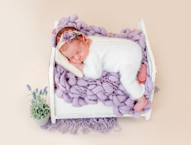 Hermoso recién nacido durmiendo en una cama pequeña