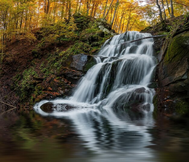 Hermoso reflejo de cascada de otoño en el lago