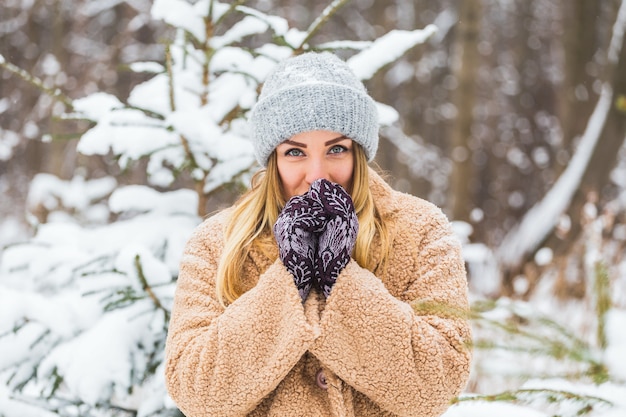 Hermoso retrato de invierno de mujer joven en el paisaje nevado de invierno.