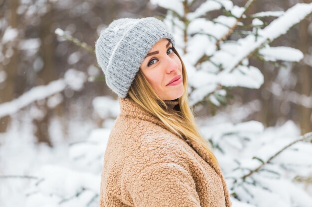 Hermoso retrato de invierno de mujer joven en el paisaje nevado de invierno