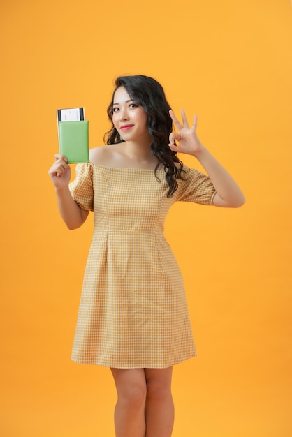 Hermoso retrato joven mujer asiática sonriente gesto bien sobre amarillo