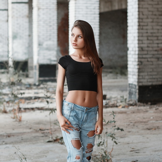 Hermoso retrato de una mujer bonita sobre las ruinas de los ladrillos