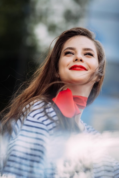 Un hermoso retrato de una mujer con lápiz labial rojo brillante y una bufanda alrededor