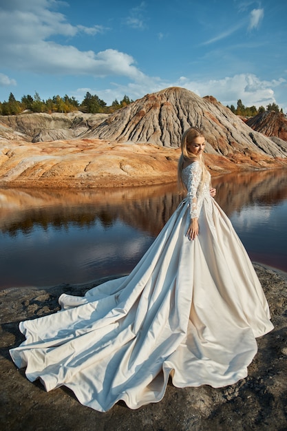 Hermoso retrato de una mujer en un paisaje fabuloso en las montañas, una boda en la naturaleza, una niña en un vestido largo.