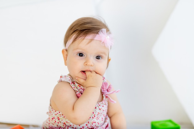 Hermoso retrato de niña chuparse el dedo en ropa roja