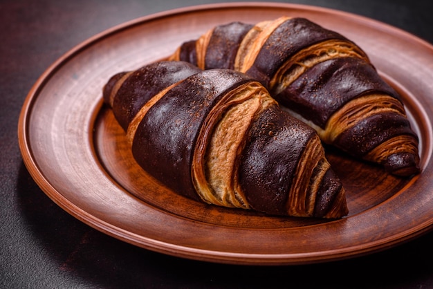 Hermoso y sabroso croissant crujiente fresco sobre un fondo de hormigón oscuro Postre para un delicioso desayuno nutritivo