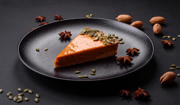 Hermoso y sabroso pastel de calabaza con rodajas en un plato de cerámica negra sobre un fondo de hormigón oscuro