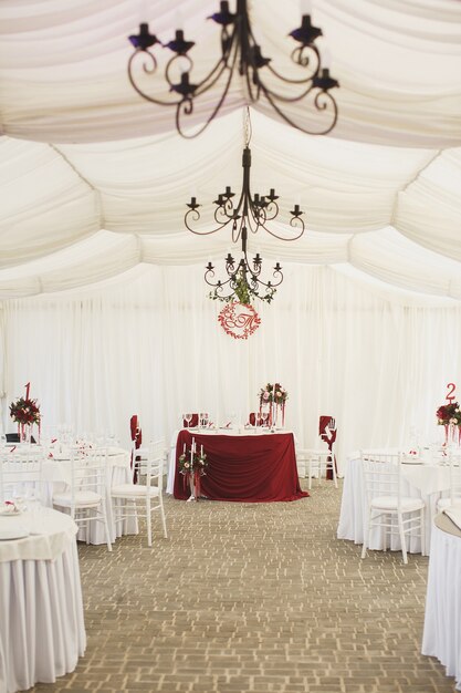 Hermoso salón de banquetes debajo de una carpa para una boda.