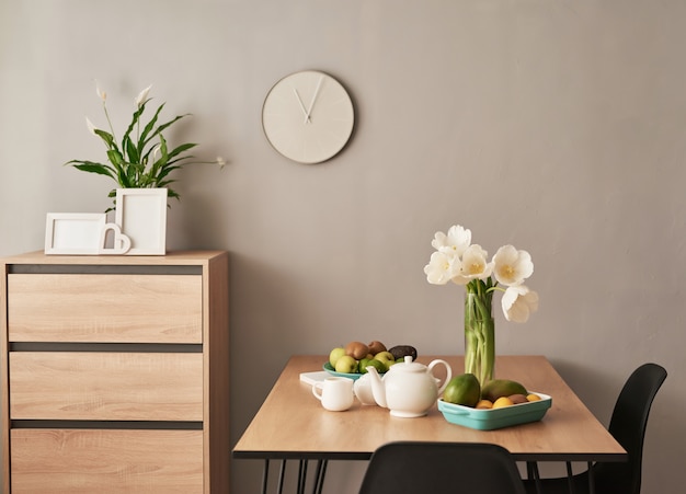 Hermoso servicio de té en mesa de madera. decoración interior del hogar, ramo de flores en florero, mesa con juego de tetera.