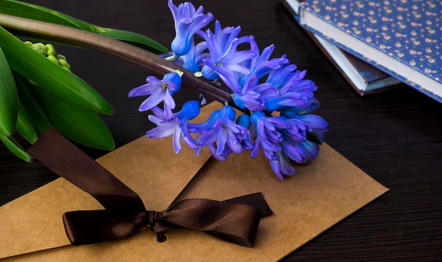 Hermoso sobre artesanal y flor de jacinto en la mesa