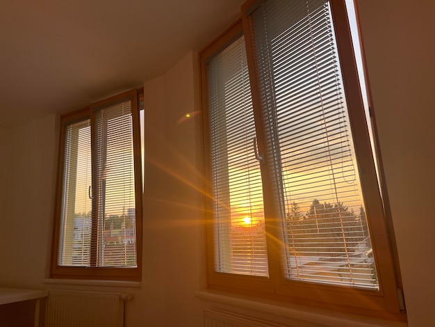 Hermoso sol matutino brillando a través de las anteojeras de la ventana en el dormitorio