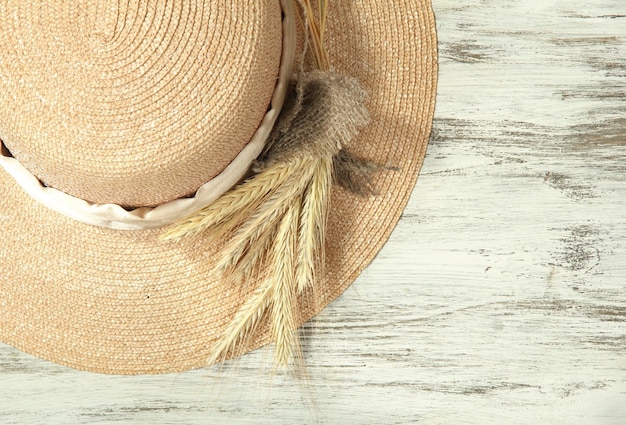 Foto hermoso sombrero de verano con espiguillas sobre fondo de madera