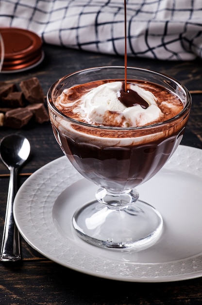 Hermoso tazón de helado de vainilla con salsa de chocolate caliente. una especie de affogato