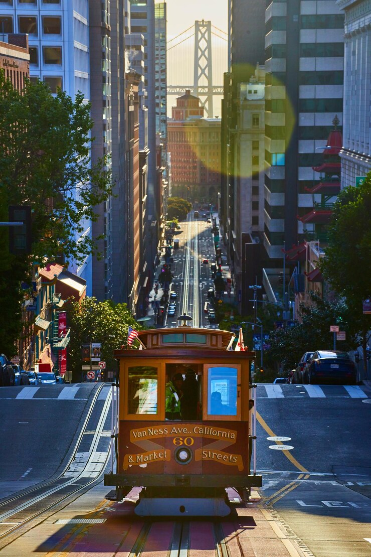 Hermoso tranvía de San Francisco al amanecer conduciendo al centro entre rascacielos hacia la bahía de Oakland
