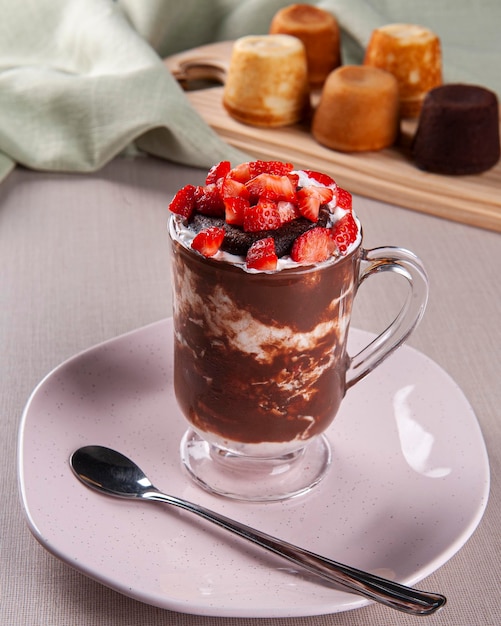 Hermoso vaso de helado de vainilla con pastel de chocolate y fruta de fresa encima