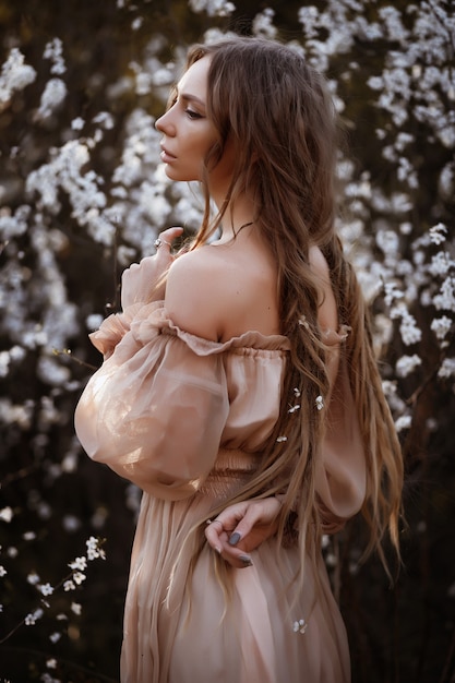 hermoso vestido marrón con hombros descubiertos. Retrato de una bella modelo en primavera. pelo largo