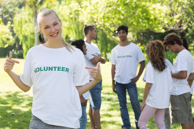 Hermoso voluntario apuntando a la camiseta