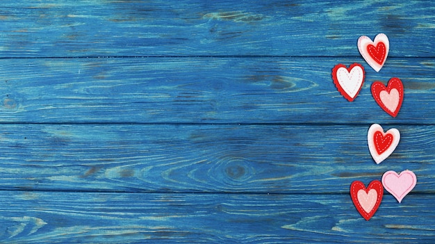 Hermosos adornos de corazón rojo sobre un fondo azul de madera para el día de San Valentín, accesorios para el día de San Valentín, fiesta del amor en febrero