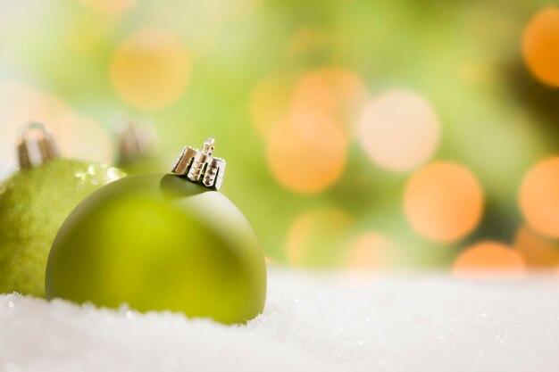 Hermosos adornos navideños de color verde mate sobre copos de nieve sobre un fondo abstracto con espacio para su propio texto