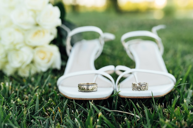 Hermosos anillos de boda de oro blanco se encuentran en zapatos de novia