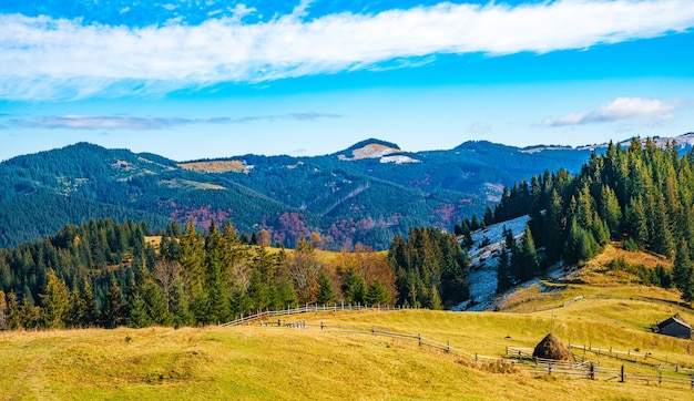 Hermosos bosques coloridos que cubren las montañas de los Cárpatos y un pequeño pueblo