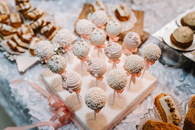 Hermosos cake pops Mesa colorida con dulces y golosinas para la recepción de la boda mesa de postres decorada Deliciosos dulces en buffet de dulces Mesa de postres para una fiesta pasteles cupcakes