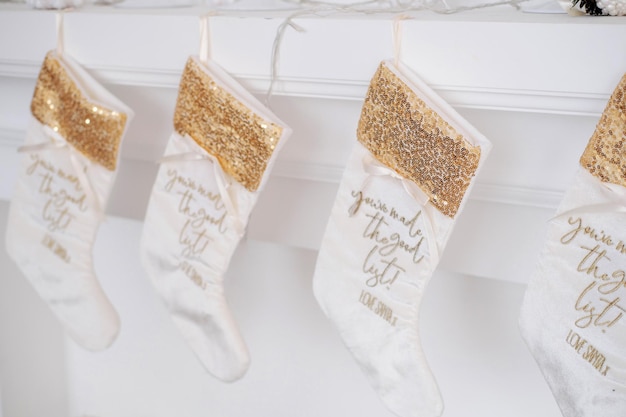 Hermosos calcetines navideños blancos colgados en la chimenea