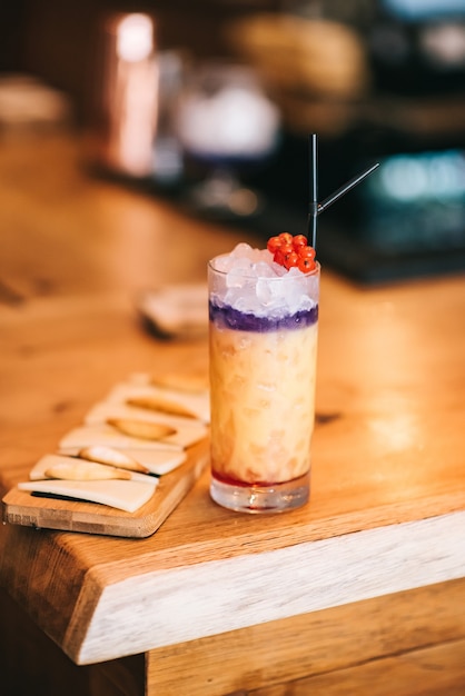 Hermosos cócteles alcohólicos en barra de bar de madera y bocadillo de queso