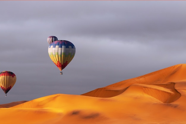 Hermosos coloridos globos de aire caliente y espectaculares nubes sobre las dunas de arena en el desierto de Namib