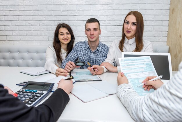 Foto hermosos consultores financieros con formulario de impuestos 1040 en la oficina