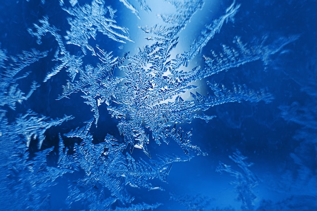 Hermosos copos de nieve congelados sobre vidrio, fondo de foto macro, tema de invierno