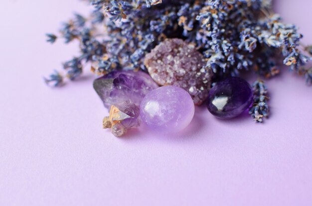 Hermosos cristales de amatista y piedra de cuarzo rosa redonda con ramo de lavanda seca. Amuletos mágicos. Copia espacio