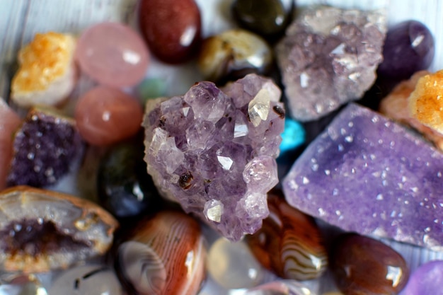 Hermosos cristales de amatista redondos de piedra de cuarzo rosa y ágata de bostwana sobre un fondo de madera Amuletos mágicos