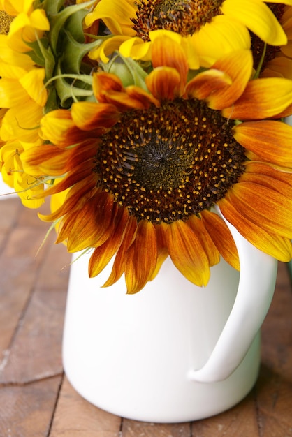 Hermosos girasoles en jarra sobre fondo de madera