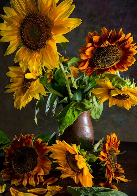 Hermosos girasoles en jarrón sobre la mesa. Bodegón artístico