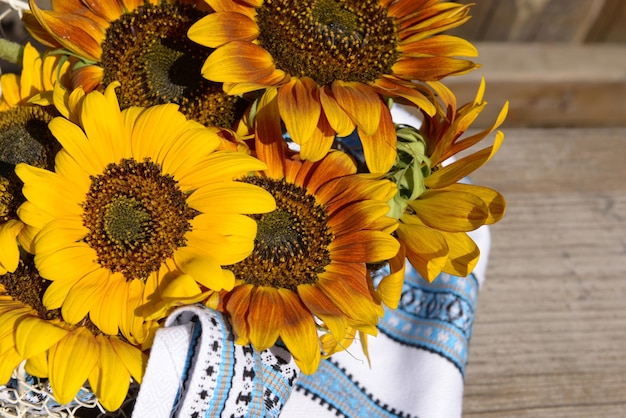 Hermosos girasoles con servilleta en canasta en un banco al aire libre