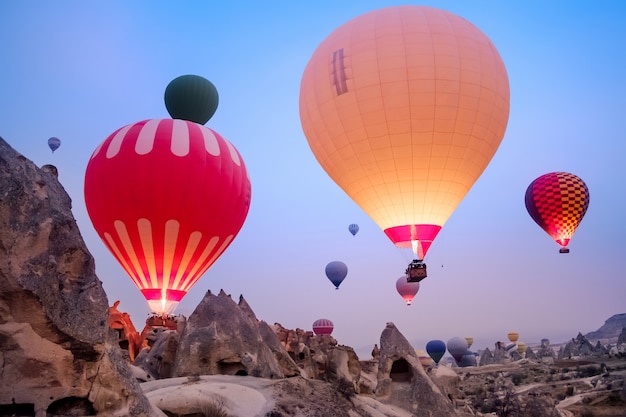 Hermosos globos aerostáticos volando sobre el paisaje de Capadocia al amanecer